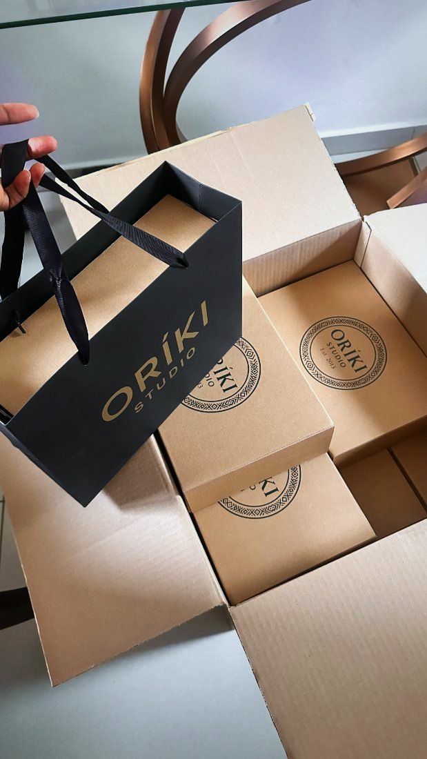 Oríki Studio gift bag in black and gold with printed kraft boxes